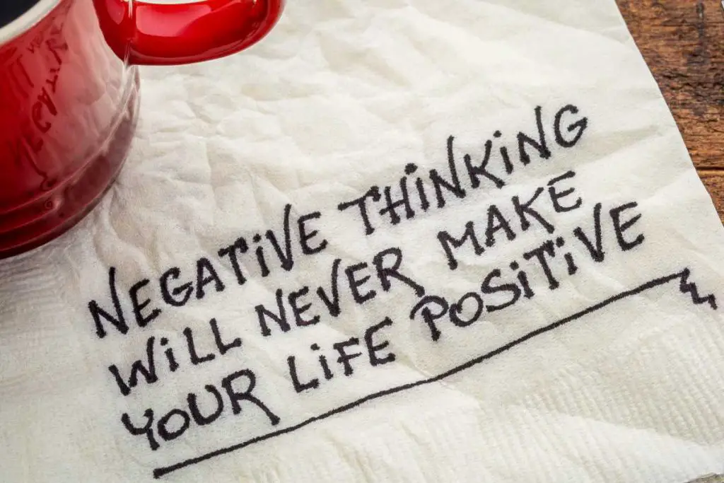 napkin under a red coffee cup that reads 'negative thinking will never make your life positive'