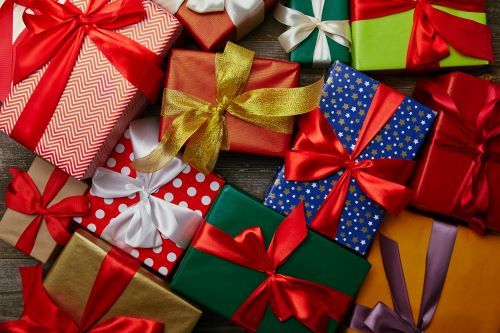 Flat lay with christmas presents wrapped in different wrapping papers with ribbons on wooden surface