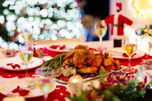 Image of perfectly decorated festive dinner table with glowing christmas tree lights in the background