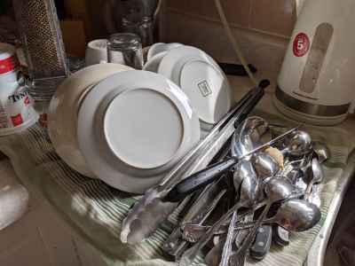 Image shows clean dishes on a towel air drying